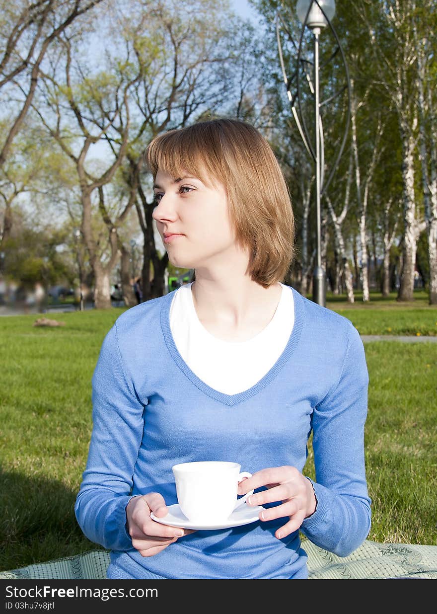 Girl drinking tea in the park. Girl drinking tea in the park