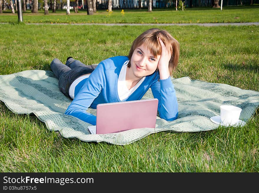 Beautiful girl working on laptop in the park. Beautiful girl working on laptop in the park