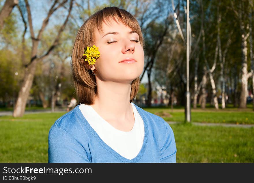 Smiling young girl sitting in the park. Smiling young girl sitting in the park