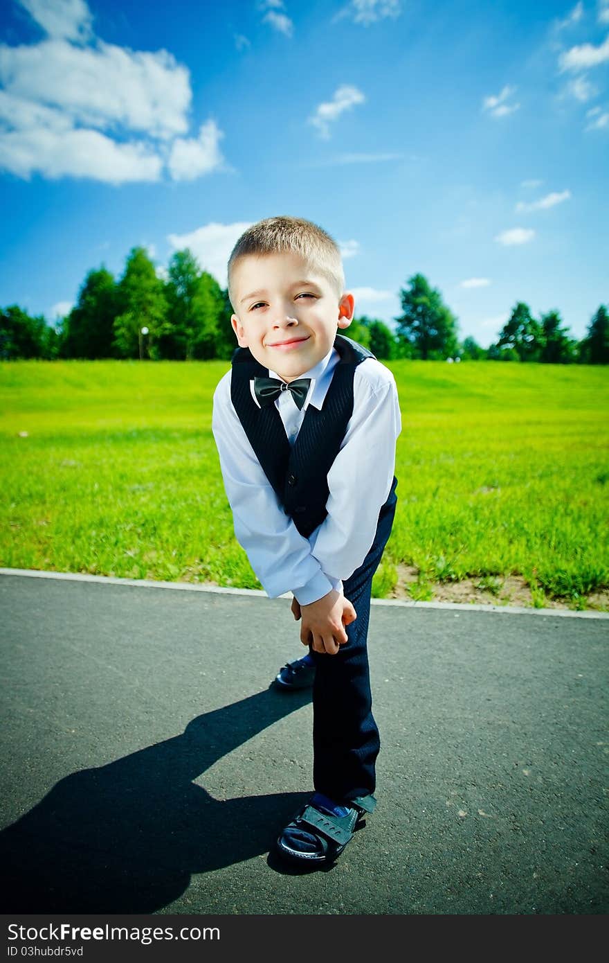 Little boy in a shirt and vest in park