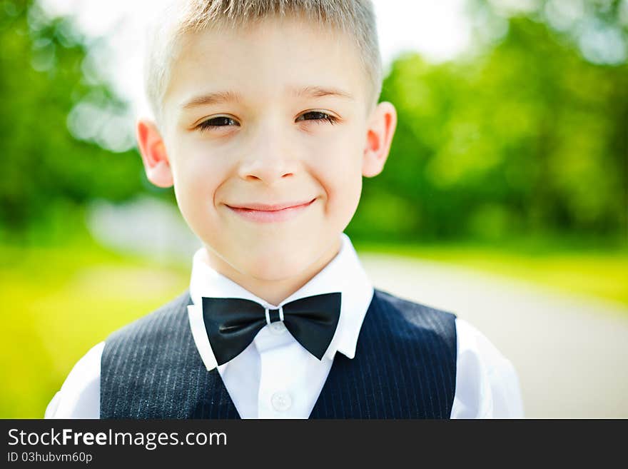 Little boy in a shirt and vest in park