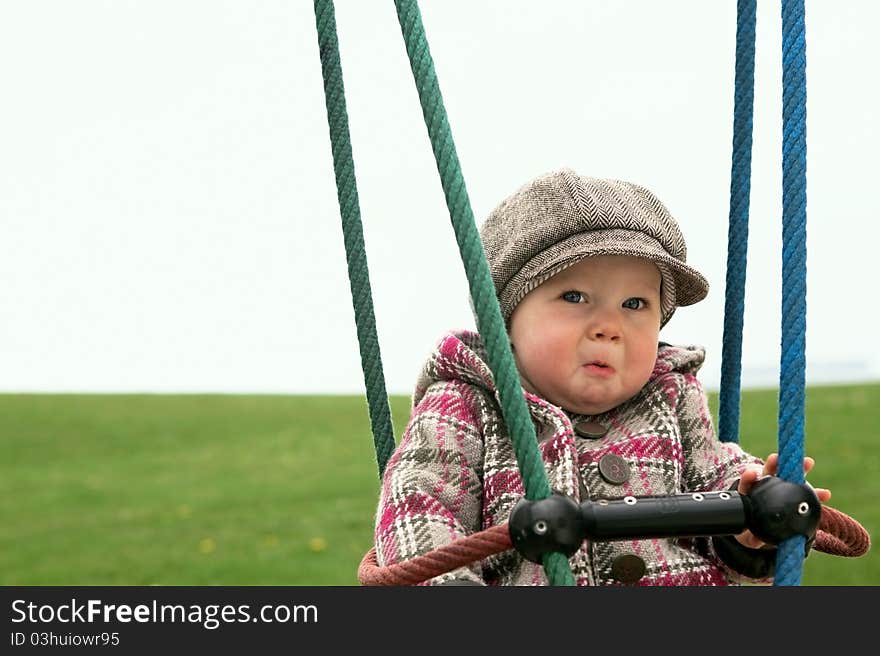 Sad baby girl on a swing