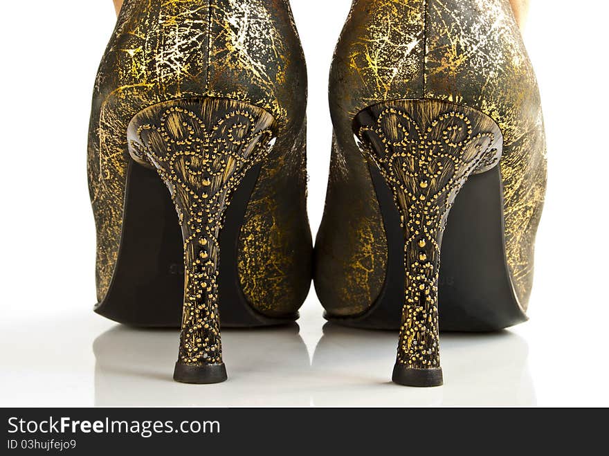 A pair of golden high-heeled shoes. Rear view. A pair of golden high-heeled shoes. Rear view.