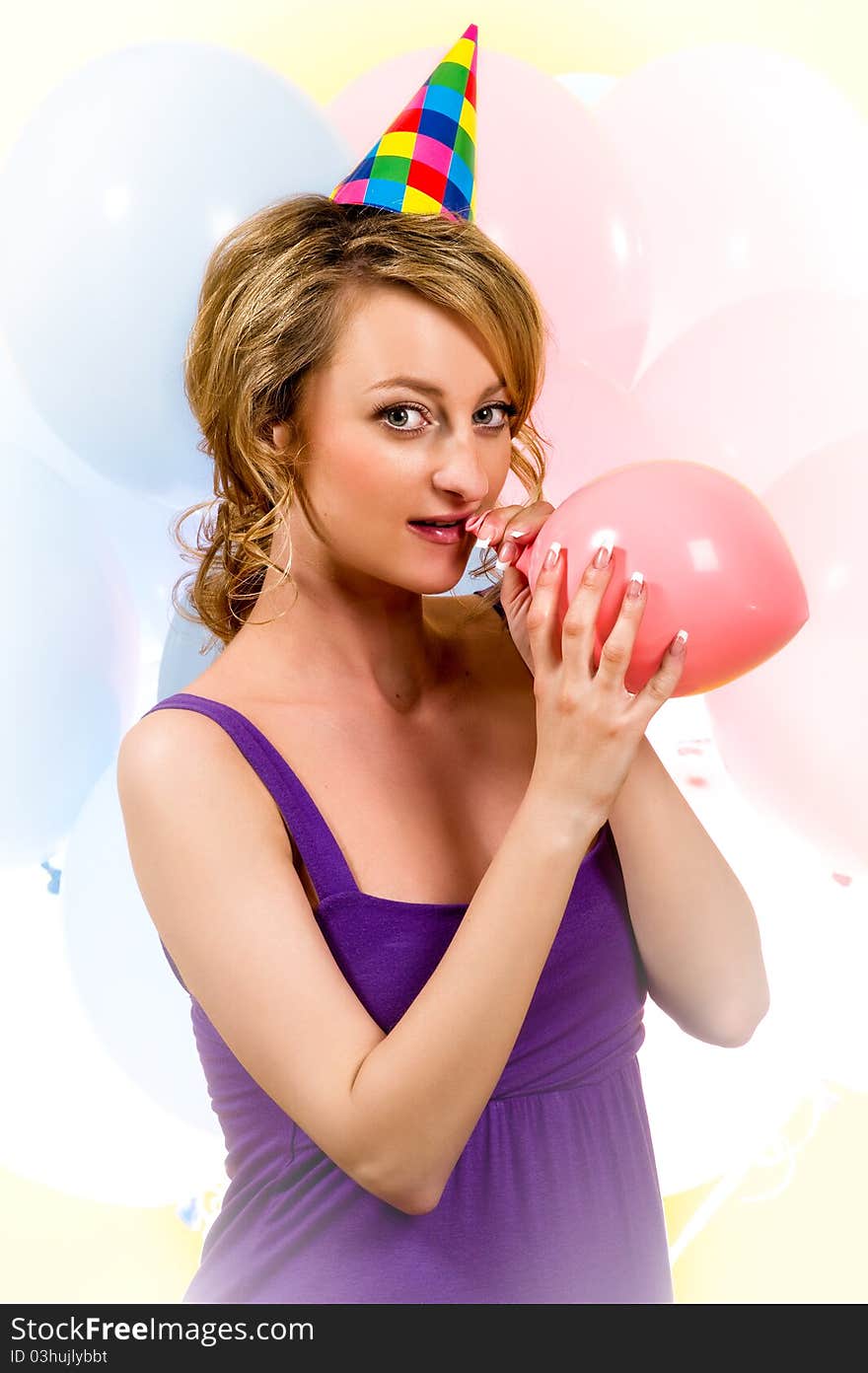 Lovely girl blowing a pink balloon indoors