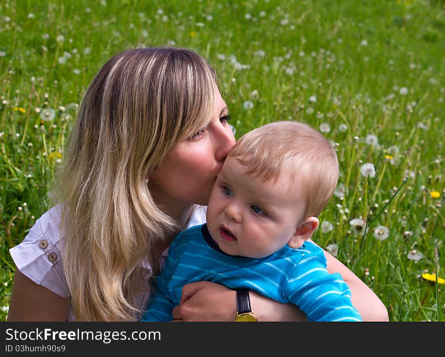 Young mother with her son on the green grass. Young mother with her son on the green grass