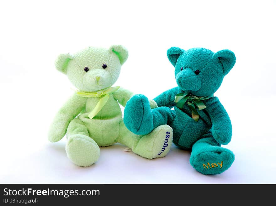 Two teddy bears sit next