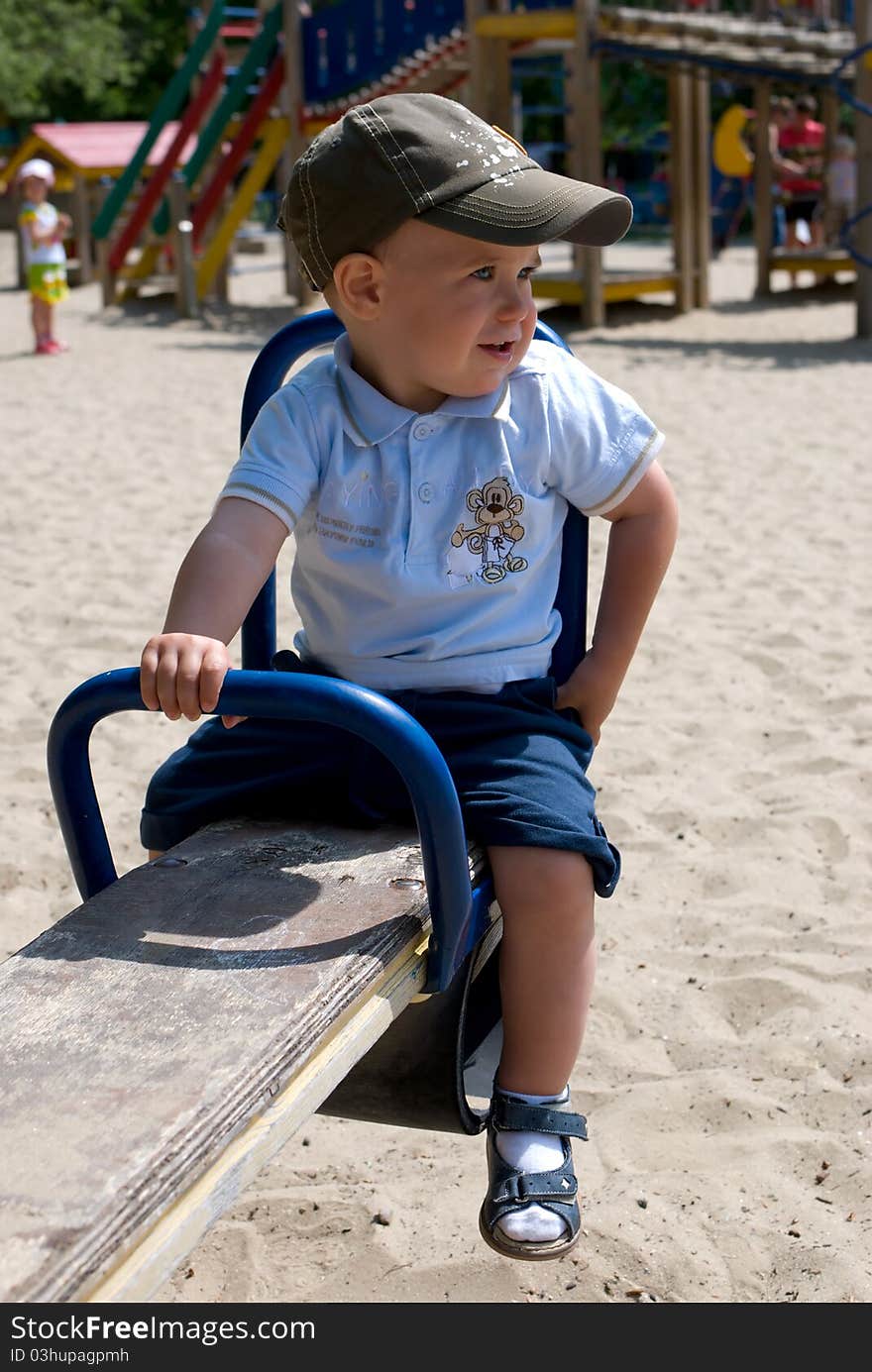 Little boy on a swing on a playground. Little boy on a swing on a playground