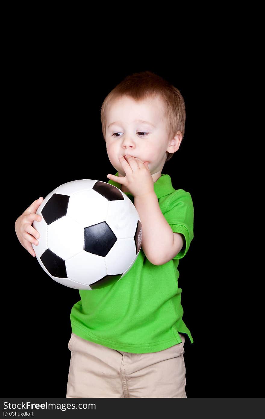 A cute child poses with his soccer ball. A cute child poses with his soccer ball.