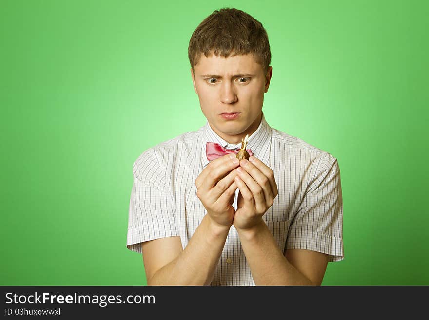 Closeup of a young man in a shirt and bow tie with a tulip bulb, thinking what to do with the onion. nerd . Parody. Closeup of a young man in a shirt and bow tie with a tulip bulb, thinking what to do with the onion. nerd . Parody