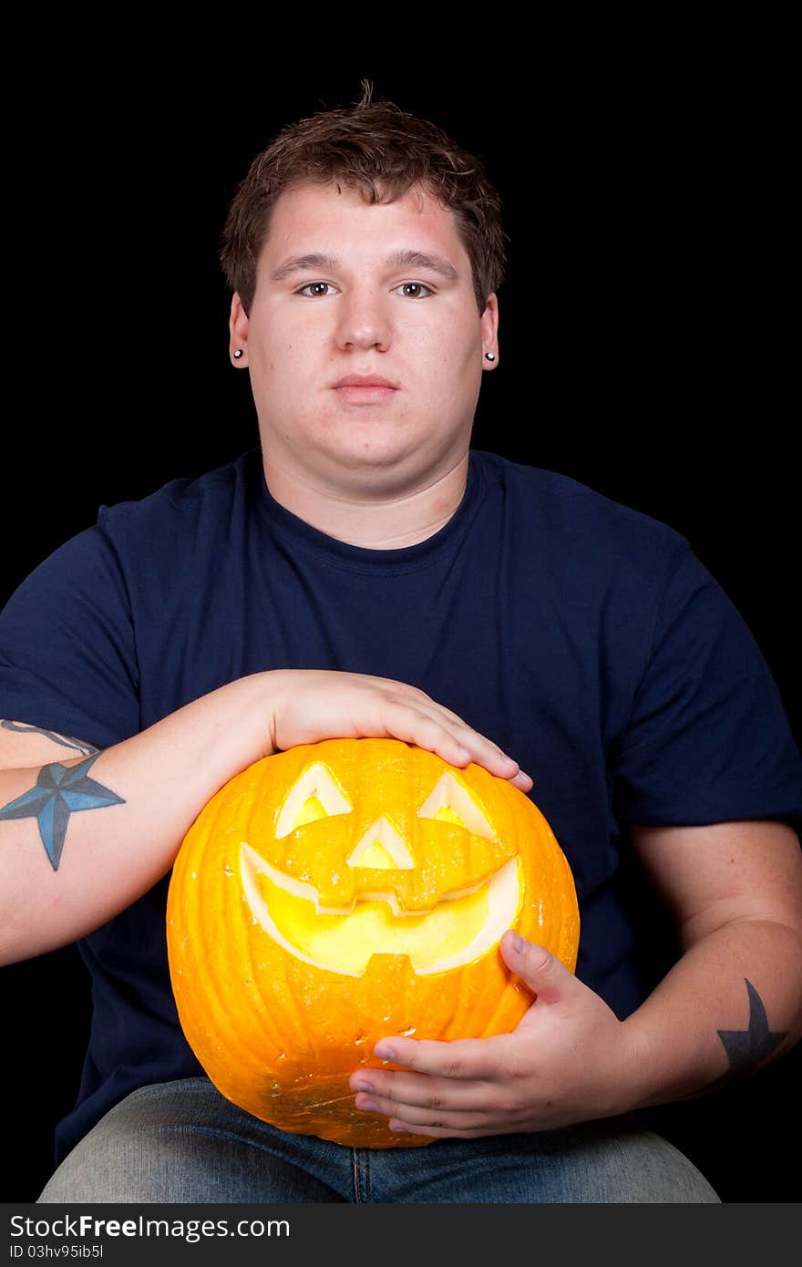 Young Man In A Blue Shirt And A Pumpkin