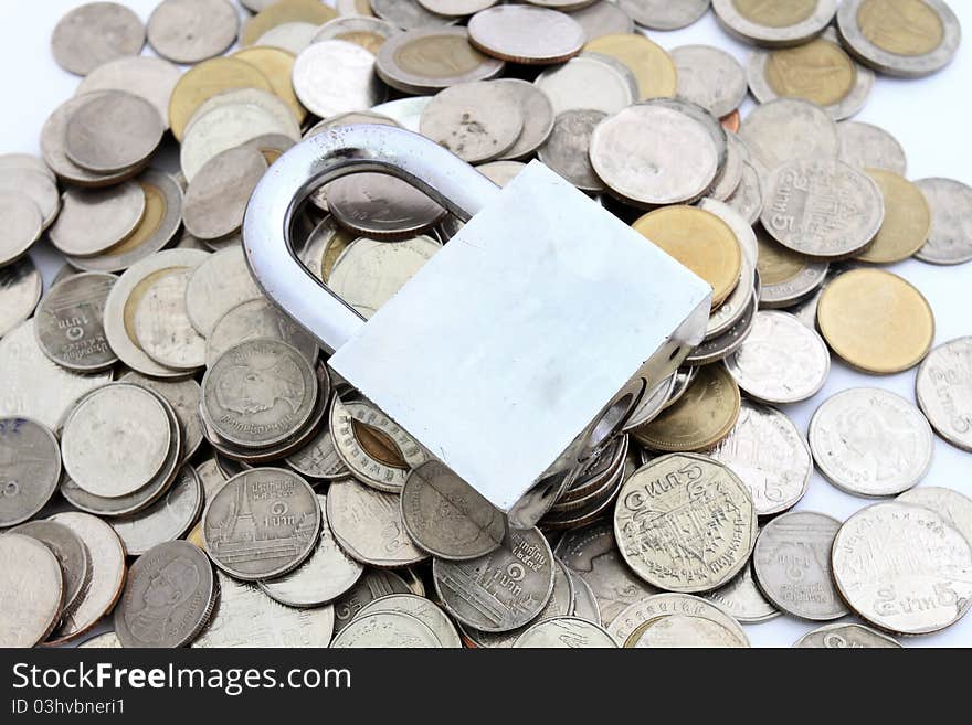 Locked Money Concept.  coins surround heavy duty locked padlock on white background.