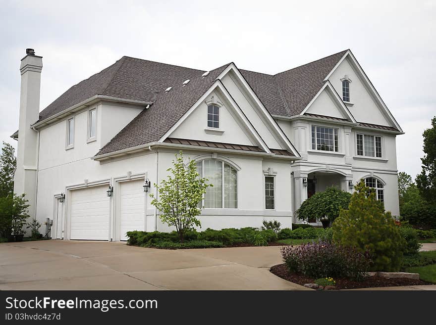 Image of a single family home with many windows and beautiful landscaping. Image of a single family home with many windows and beautiful landscaping.