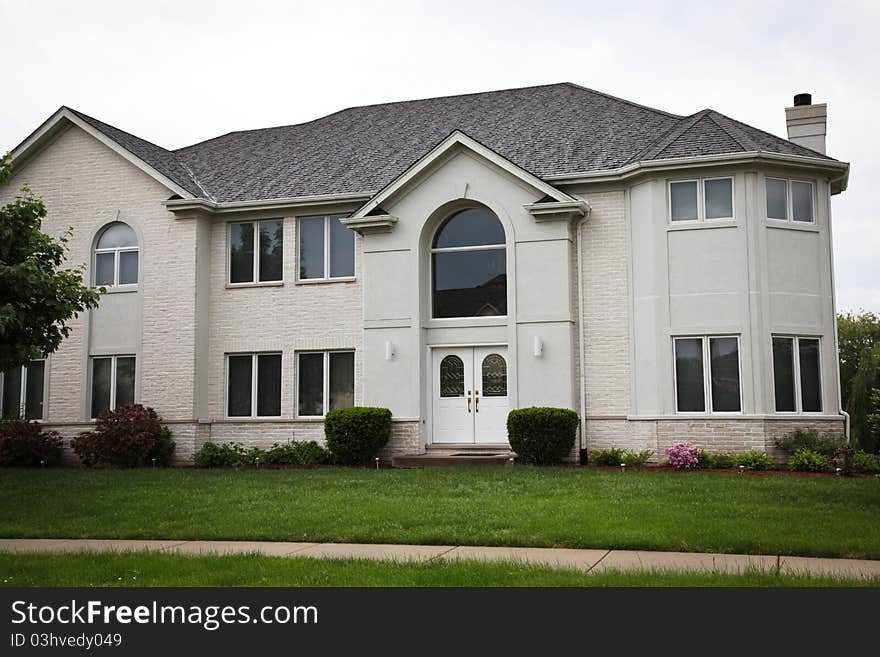 Image of a single family home with many windows and beautiful landscaping. Image of a single family home with many windows and beautiful landscaping.