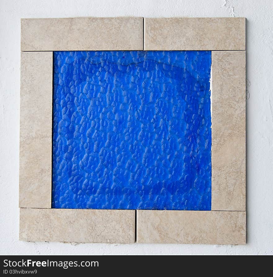 Blue glass tile framed on the wall