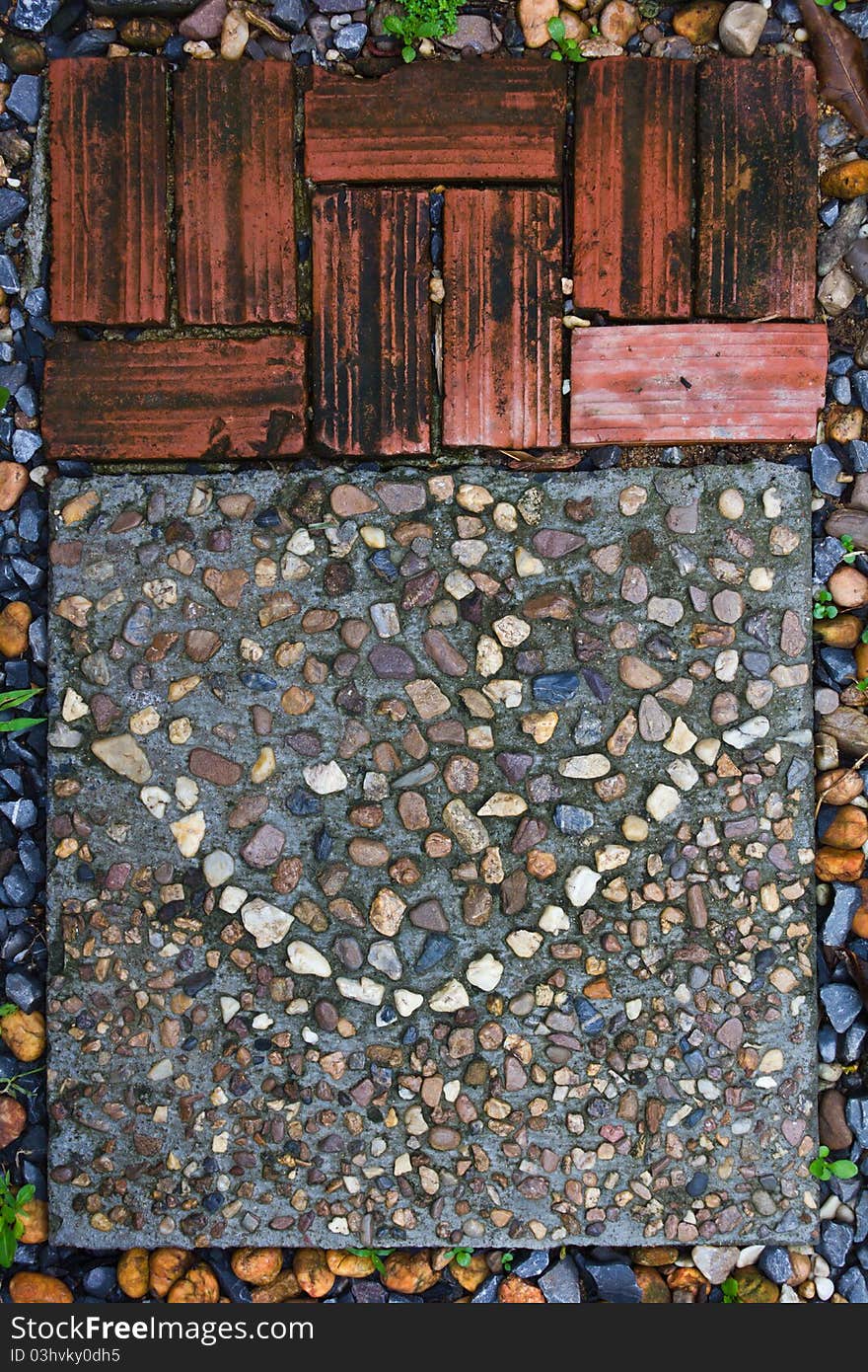 Bricks and stones strewn park adjacent to the cement step. Bricks and stones strewn park adjacent to the cement step.