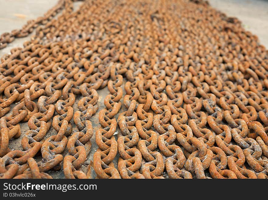 A lot of rusty metal chains lie on the deck of the ship. A lot of rusty metal chains lie on the deck of the ship