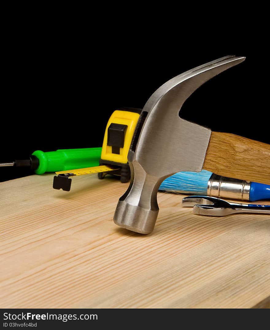 Hammer and other tool on wooden brick