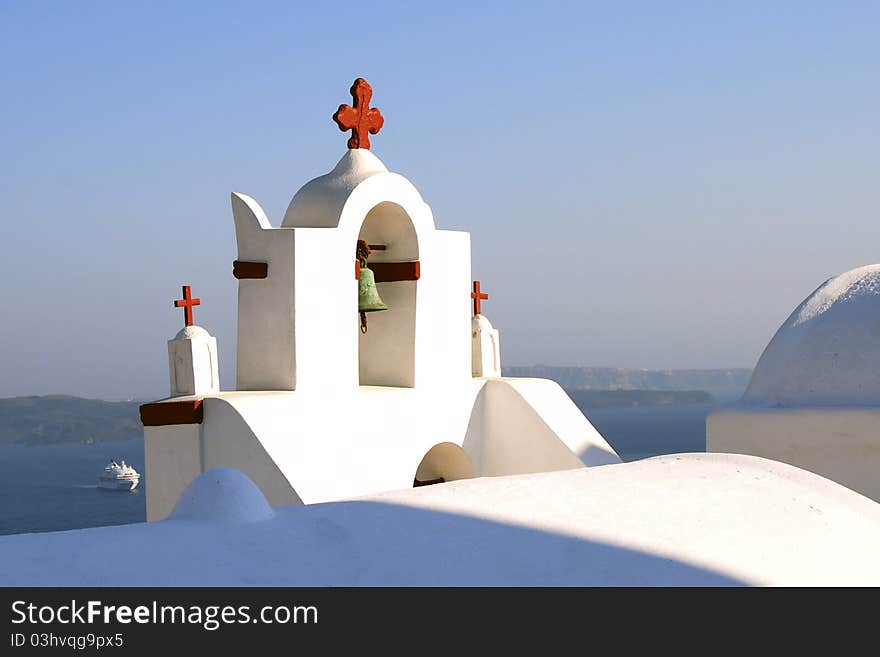 Red cross on Church bell tower on Santorini