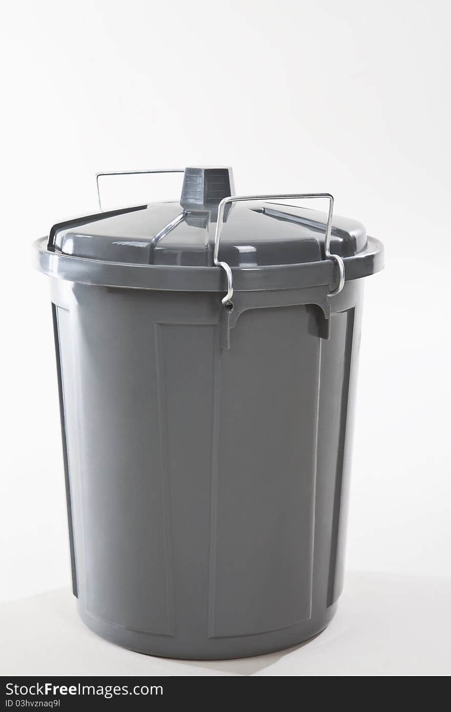 A grey wastebasket on white background