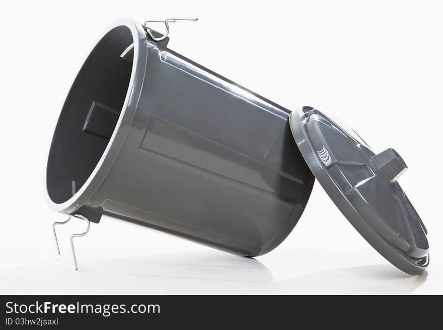 A grey wastebasket on white background