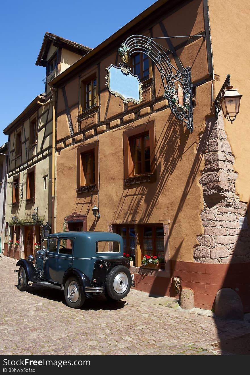 French traditional house with half-timbered wall. La route du vin – route of vines – village in Alsace - France. An old car in front of a restaurant. French traditional house with half-timbered wall. La route du vin – route of vines – village in Alsace - France. An old car in front of a restaurant.