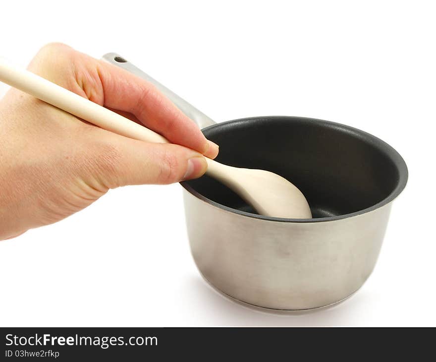 Stainless steel kettle, with wooden spatula and human hand, isolated towards white background