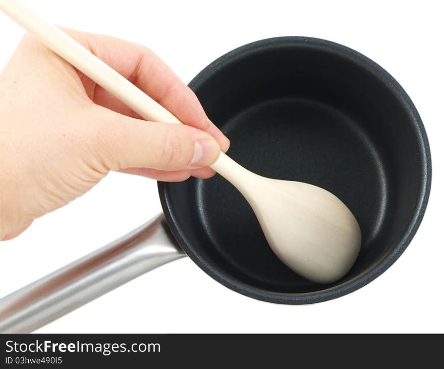 Stainless steel kettle, with wooden spatula and human hand, isolated towards white background