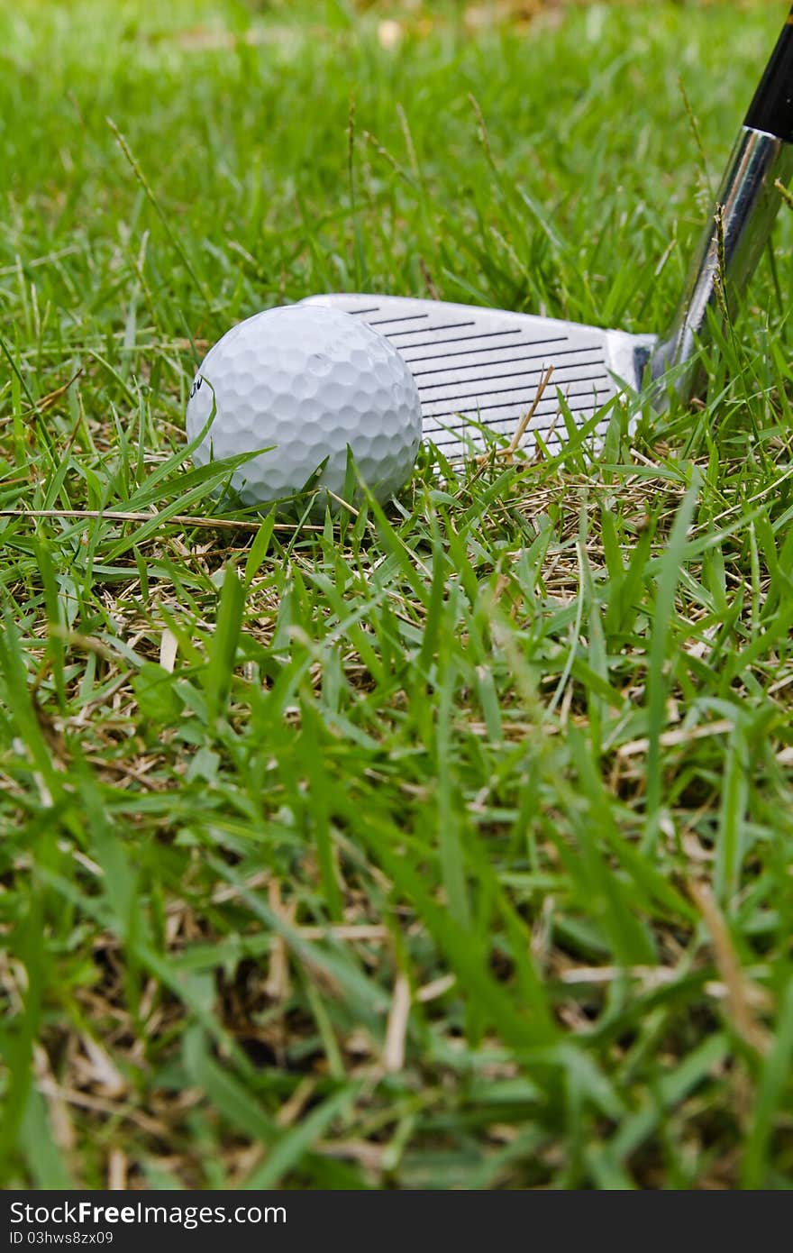 Golf ball and wedge in rough grass situation. Golf ball and wedge in rough grass situation