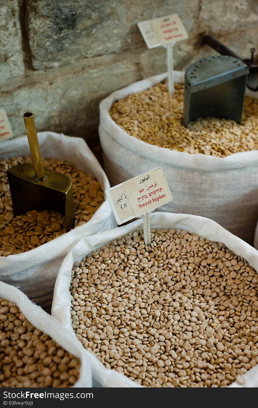 Sacks of dry beans with various metal scoops line the walls of a market in Nazareth, Israel. Sacks of dry beans with various metal scoops line the walls of a market in Nazareth, Israel.