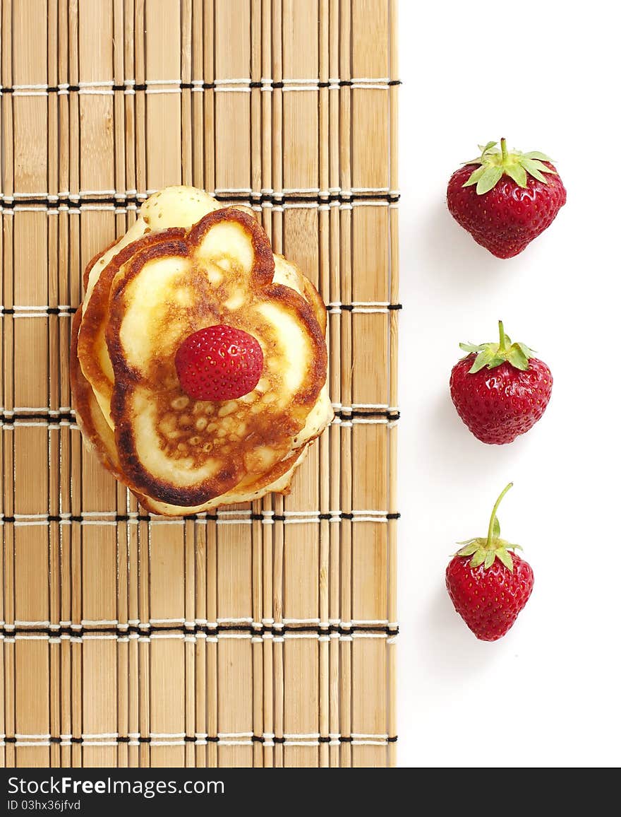 Pancakes with strawberry on a wicker cloth