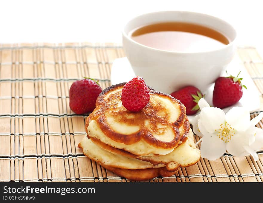 Pancakes with strawberry and cup of tea