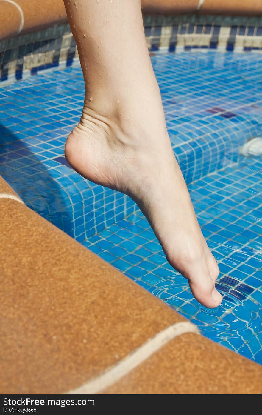 Swimming and women's foot touches the water. Swimming and women's foot touches the water