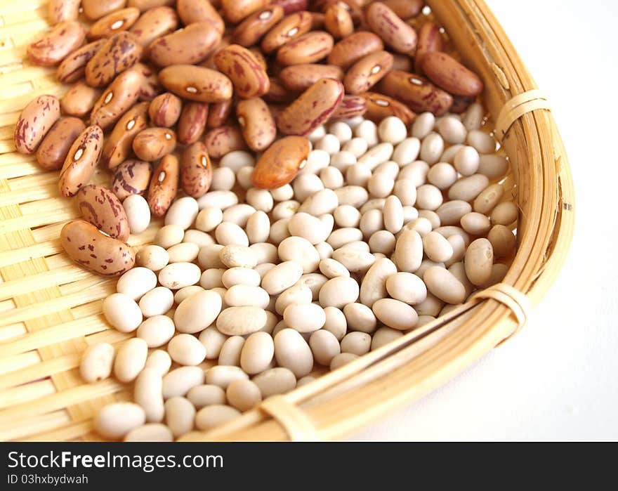 Pods of red and white beans on white background