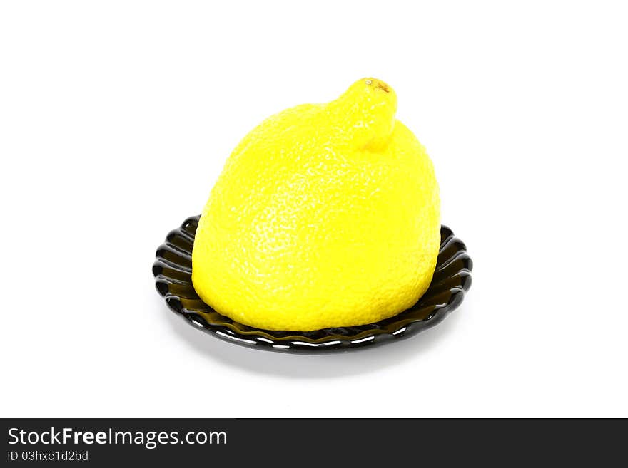 Lemon on black plate on a white background. Lemon on black plate on a white background