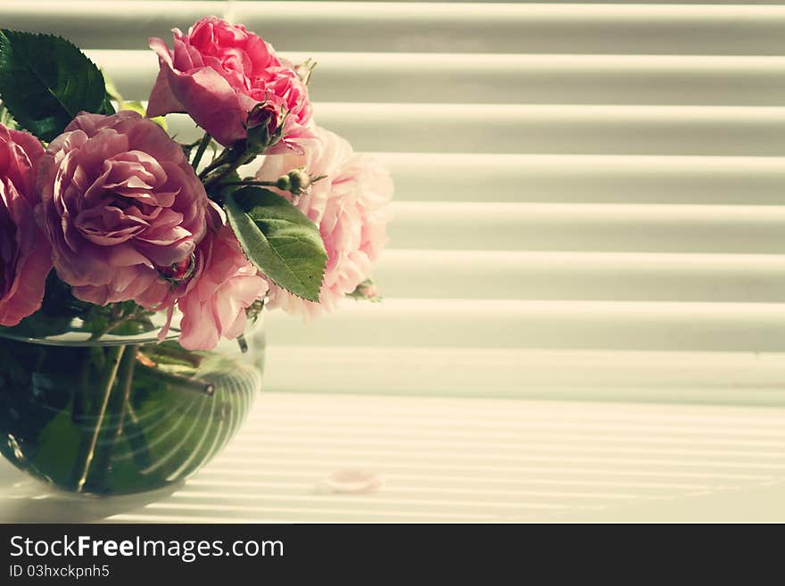 Vintage toned image of bunch a roses at window. Vintage toned image of bunch a roses at window