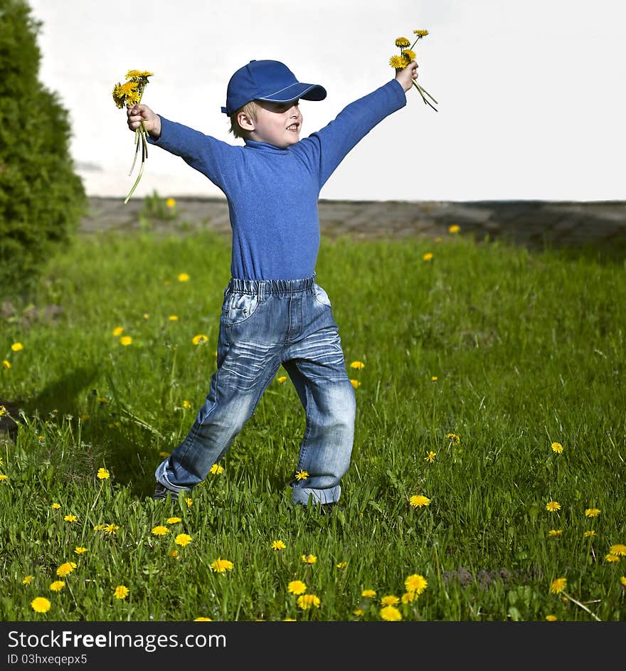 Happy boy with dandelions playing