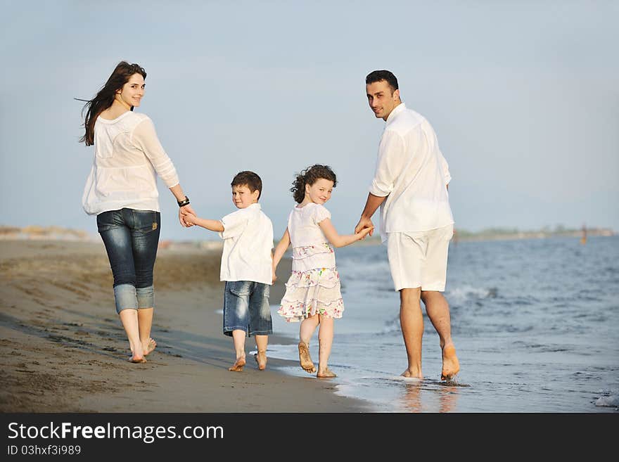 Happy young family have fun on beach at sunset