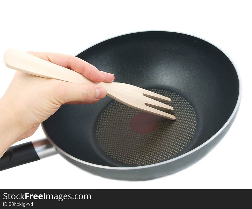 Frying pan with wooden spatula, isolated with human hand towards white background