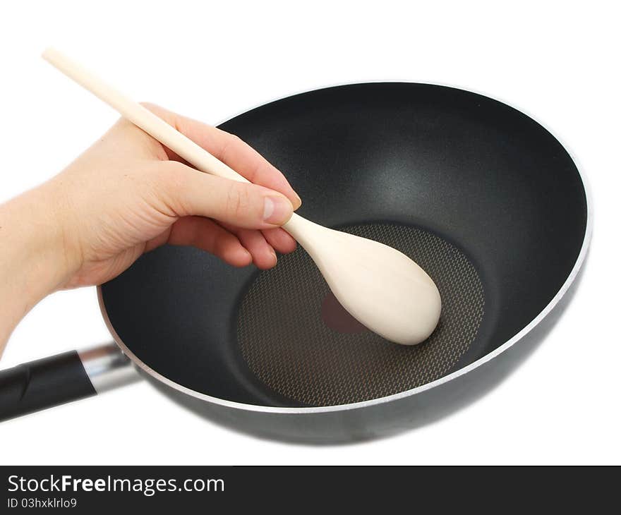 Frying pan with wooden spatula, isolated with human hand towards white background