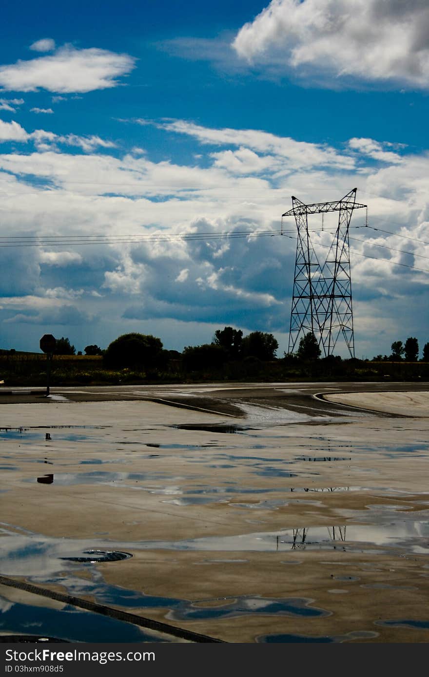 Shot of a road after a storm and rainfall. With electric pole and cables.