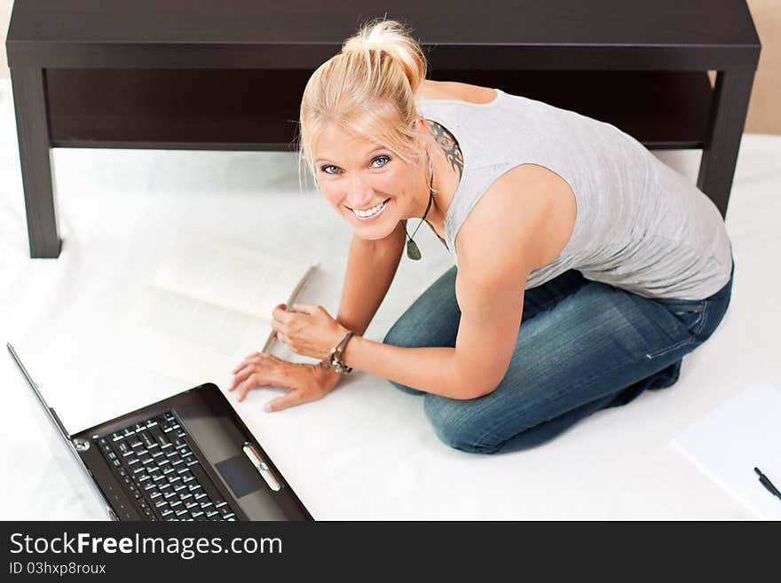 Young smiling attractive woman works on her laptop. Young smiling attractive woman works on her laptop