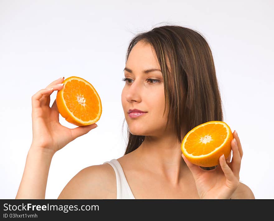 Young woman holding two halves of orange. Young woman holding two halves of orange