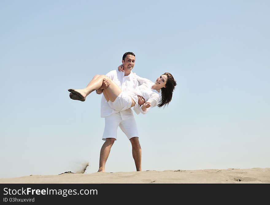 Happy young couple have fun and romantic moments on beach at summer season and representing happynes and travel concept. Happy young couple have fun and romantic moments on beach at summer season and representing happynes and travel concept