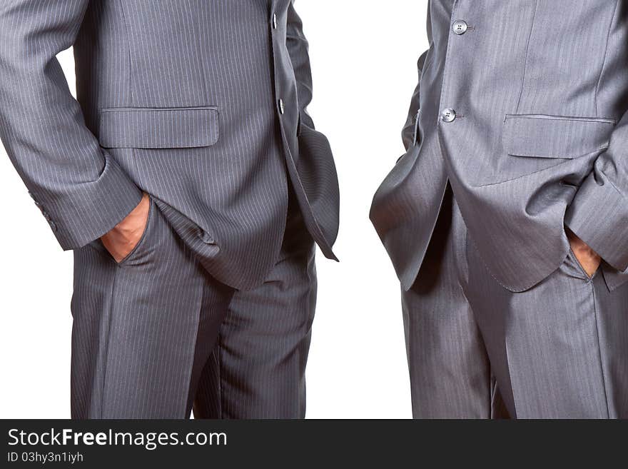 Professionally well dressed two caucasian businessmen in elegant suits, top managers standing holding hands in pockets isolated on white background. Concept corporate. Professionally well dressed two caucasian businessmen in elegant suits, top managers standing holding hands in pockets isolated on white background. Concept corporate.