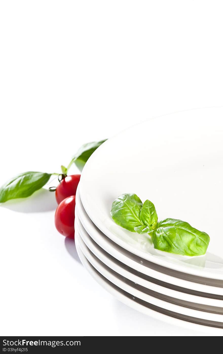 Plate decorated with basil and tomato