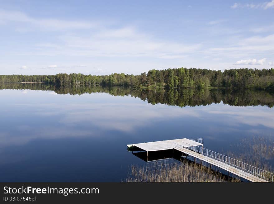 Russian north. The bridge and beautiful wood at lake. Russian north. The bridge and beautiful wood at lake