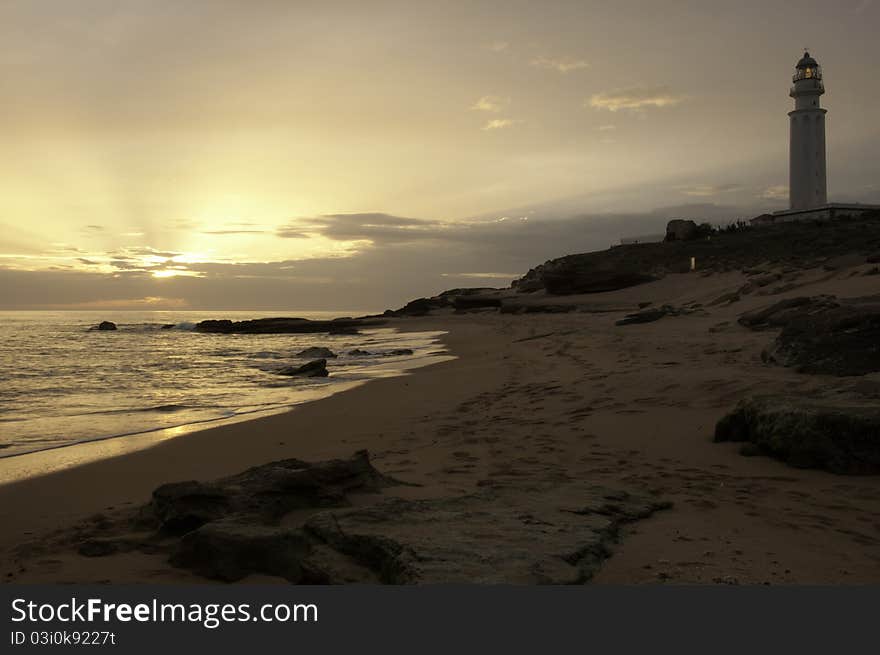 Sunset on a beach in Spain with a lighthouse. Sunset on a beach in Spain with a lighthouse