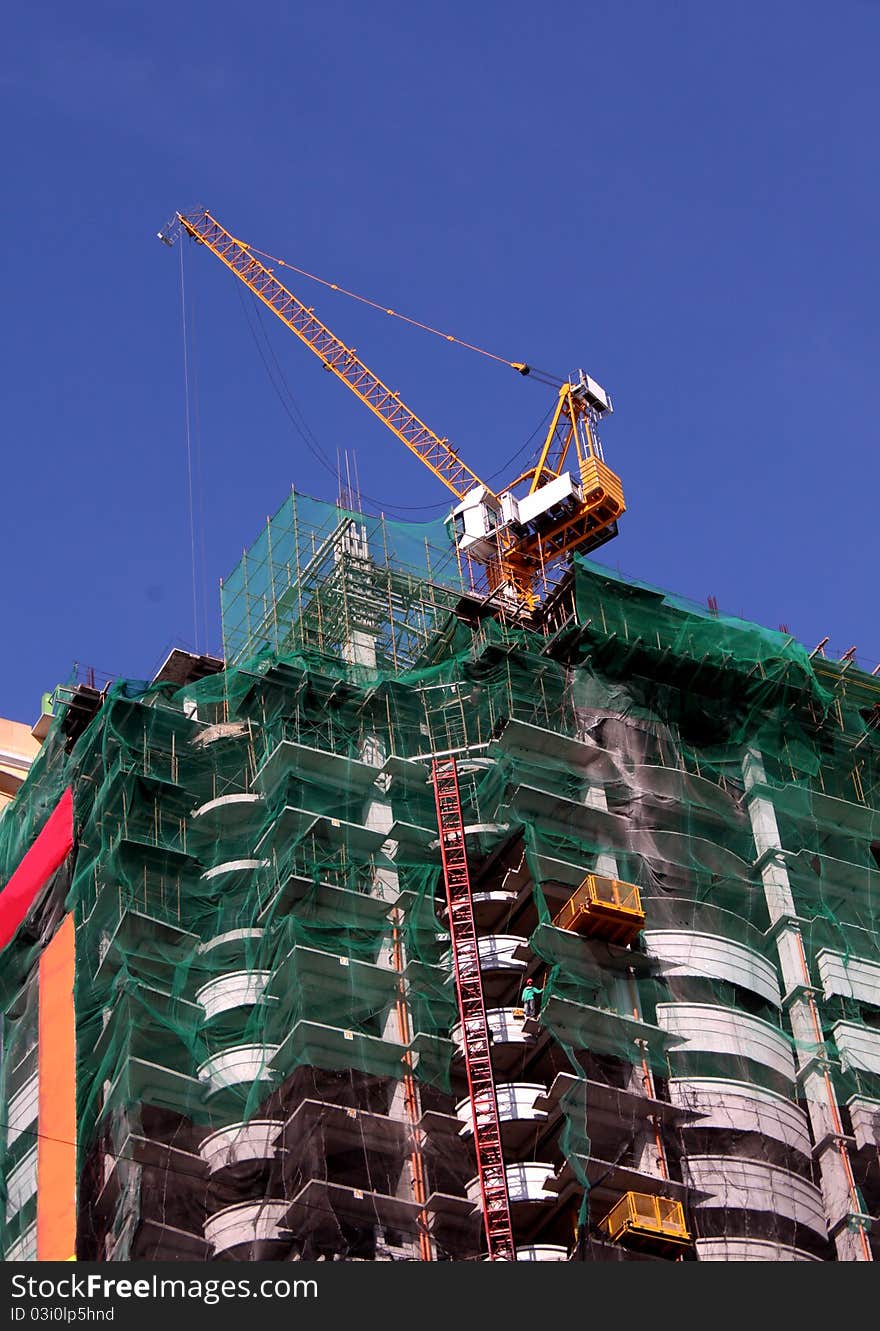 A tower condominium under construction using modern technologies and modern equipments like the one shown, the tower crane.