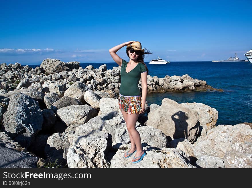 Young female tourist in hat on the sea beach