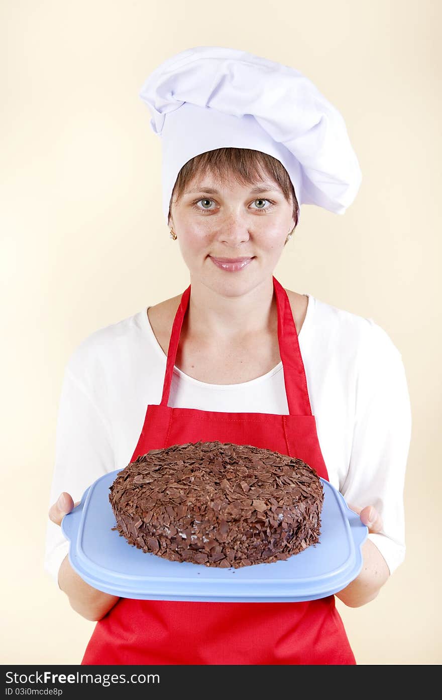 Girl chef with a cake in a red apron